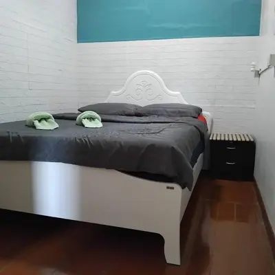 a white bed with two green towels on it at Sleepwith me Hostel in Bangkok