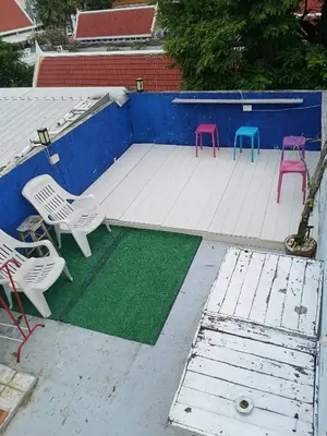 a group of chairs and a green mat in a pool at Sleepwith me Hostel in Bangkok