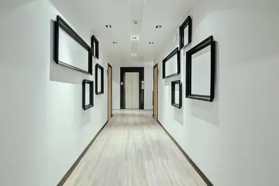 a hallway with a row of paintings on the wall at Three Sukhumvit Hotel - SHA Plus Certified in Bangkok