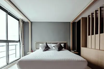 a large bed in a room with a large window at Three Sukhumvit Hotel - SHA Plus Certified in Bangkok