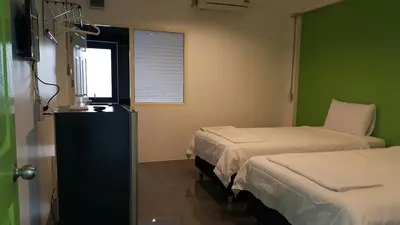 a hospital room with two beds and a window at Varinda Hostel in Bangkok