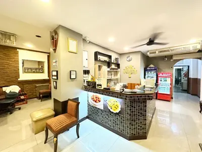 a restaurant with a counter and chairs in a room at Baan at Khaosan Hostel in Bangkok