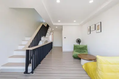 a living room with stairs and a yellow couch at Advanced townhouses can accommodate 14 people, with high-speed Wi Fi and parking on Netflix in Ban Non Yang Ngam