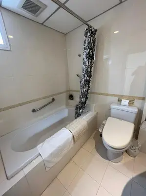 a bathroom with a toilet and a bath tub at Jhouse Thonglor in Khlong Toei