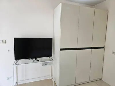 a living room with a tv and a white cabinet at Cozy 1br walk to BTS and Airport Rail Link Close to Malls m11 in Bangkok
