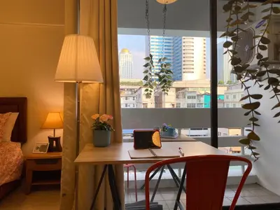 a room with a desk with a laptop and a window at Cozy 1br walk to BTS and Airport Rail Link Close to Malls m11 in Bangkok