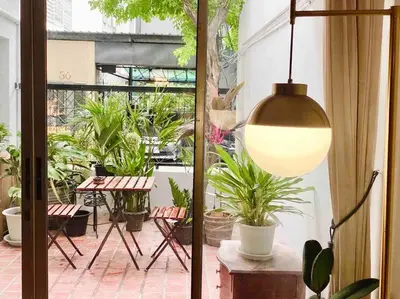 a pendant light hanging in a patio with plants at Flip Flop In Townhouse in Bangkok