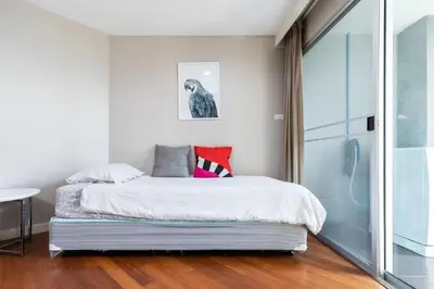 a bedroom with a bed and a glass door at MRT rame9 Jodd Fairs night market, walk for a few minutes, two bedrooms and two bathrooms in Ban Don Sai
