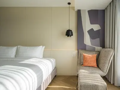 a bedroom with a bed and a chair at Stay Plus Hotel Bangkok in Bangkok
