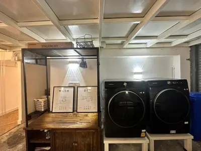 a washer and dryer in a room with a mirror at The White Den Sukhumvit 44 in Bangkok