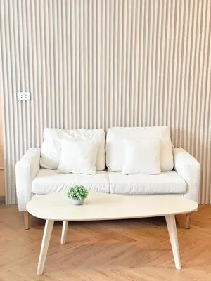a living room with a white couch and a table at NK hostel in Thung Si Kan