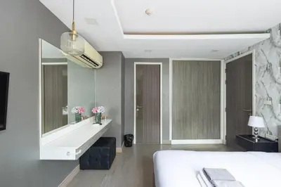 a bedroom with a bed and a large mirror at Dazzle Sukhumvit 7 by LeFoyer in Bangkok