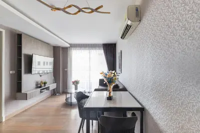 a living room with a table and chairs and a room at Dazzle Sukhumvit 7 by LeFoyer in Bangkok