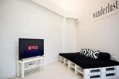 a living room with a couch and a tv at Baan Khun Pra APT No4 Duplex 3BR in Bangkok