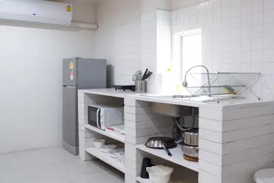 a white kitchen with a sink and a refrigerator at Baan Khun Pra APT No4 Duplex 3BR in Bangkok