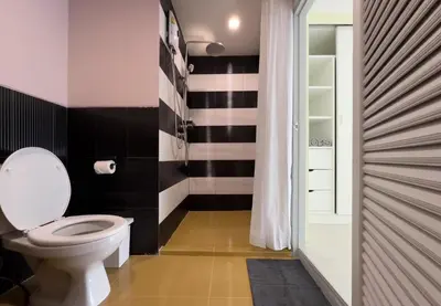 a bathroom with a toilet and black and white stripes at Baan Khun Pra APT No4 Duplex 3BR in Bangkok