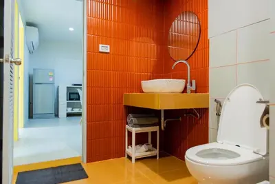 a bathroom with a toilet and a mirror at Baan Khun Pra APT No4 Duplex 3BR in Bangkok