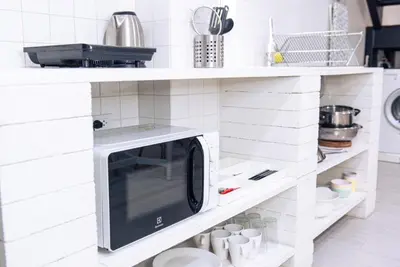 a microwave on a shelf in a kitchen at Baan Khun Pra APT No4 Duplex 3BR in Bangkok
