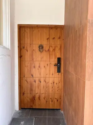 a wooden door in the corner of a room at Dado9home in Khlong Toei
