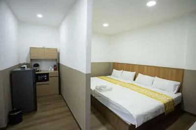 a bedroom with a bed and a small kitchen at Dado9home in Khlong Toei