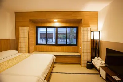 a room with two beds and a window with a television at Dado9home in Khlong Toei