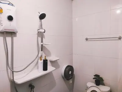 a white bathroom with a shower and a toilet at Back Home Backpackers Hostel in Bangkok