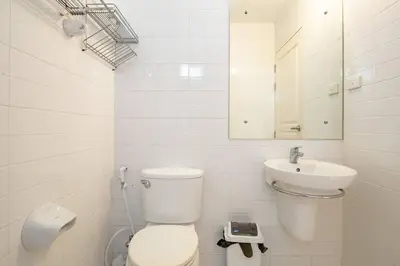 a white bathroom with a toilet and a sink at 420 House- up to 10 guests in central Bangkok. in Bangkok