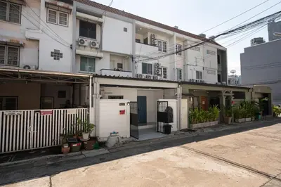 an apartment building with a white fence and plants at Spacious Haven Chatuchak Market 5BR 10 Sleeps RB1 in Ban Zong Katiam