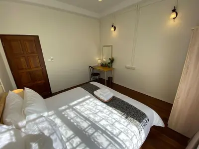 a bedroom with a bed and a table in it at 1 min walk to BTS, 3 Bed 3 Bath, Entire House in Bangkok