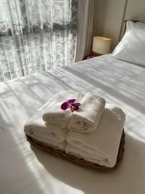 a pile of towels sitting on top of a bed at 1 min walk to BTS, 3 Bed 3 Bath, Entire House in Bangkok
