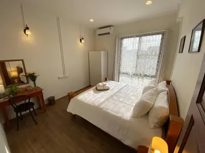 a bedroom with a white bed and a window at 1 min walk to BTS, 3 Bed 3 Bath, Entire House in Bangkok