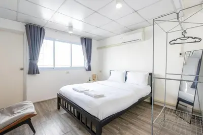 a bedroom with a bed and a chair at PICCOLO SUKHUMVIT HOSTEL- Self check-in after 6 pm in Bangkok