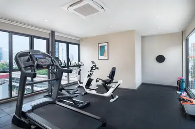 a gym with two tread machines in a room with windows at Lumen Bangkok Udomsuk Station in Bangkok