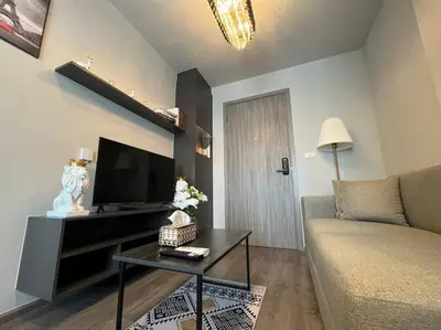 a living room with a couch and a flat screen tv at Monte Rama 9 near JodFair Market Condo in Bangkok