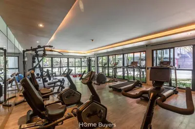 a gym with treadmills and ellipticals in a building at Monte Rama 9 near JodFair Market Condo in Bangkok
