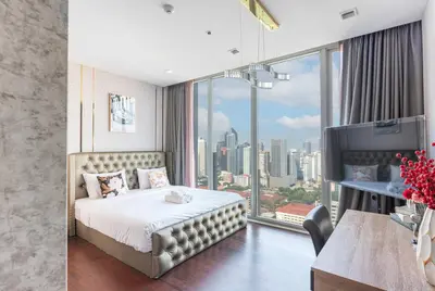 a hotel room with a bed and a large window at The Pinnacle Sukhumvit 11 by LeFoyer in Bangkok