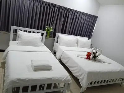 two beds with white sheets and a red toy on them at NK Guesthouse 1 in Khlong Toei