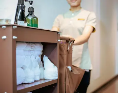 a man standing in front of a cabinet with towels at SAM E Hotel Bangkok Sathorn in Bangkok