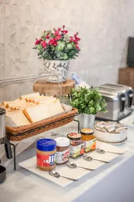 a buffet with bread and other food on a table at SAM E Hotel Bangkok Sathorn in Bangkok