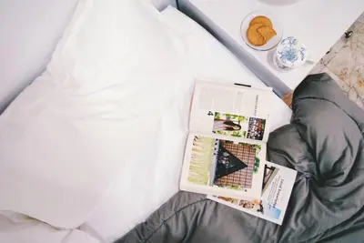 a bed with a book and a magazine on it at Double Studio, Private Bath, Shared Kitchen with Local Family by Pillows & Purrs in Bangkok