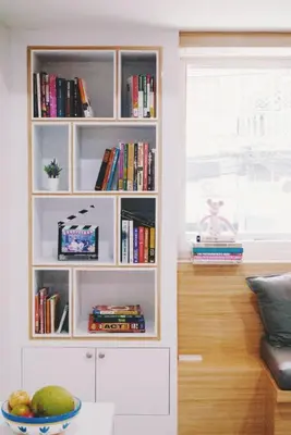 a white book shelf with a bowl of fruit in a room at Double Studio, Private Bath, Shared Kitchen with Local Family by Pillows & Purrs in Bangkok