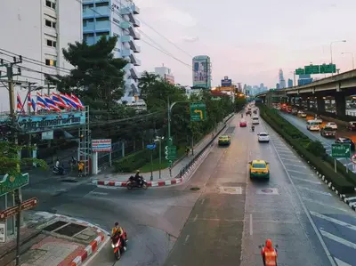 a busy city street with cars and people on motorcycles at Double Studio, Private Bath, Shared Kitchen with Local Family by Pillows & Purrs in Bangkok