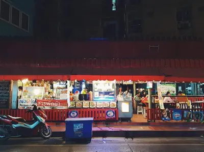 a scooter parked in front of a restaurant at night at Double Studio, Private Bath, Shared Kitchen with Local Family by Pillows & Purrs in Bangkok