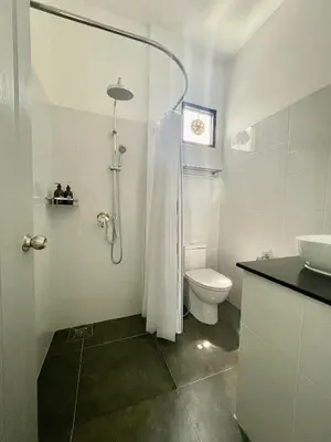 a bathroom with a shower and a toilet and a sink at Casa Luna in Bangkok