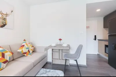 a living room with a couch and a table at Sathon-Charoen Nakhon Condo in Bangkok