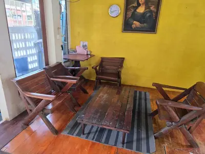 a room with chairs and a table and a clock at 206 Lovely Room with cool fan with full amenities & Free Wi-Fi in Bangkok