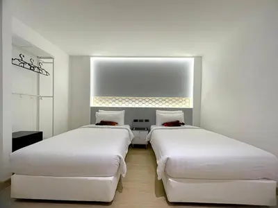 two beds in a room with white walls at Arawana Express Sukhumvit 22 in Bangkok