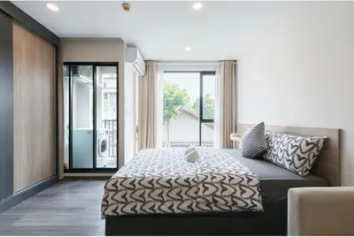a bedroom with a bed and a large window at \u6c99\u541eSathon-Charoen Nakhon\u7cbe\u54c1\u516c\u5bd3 in Bangkok