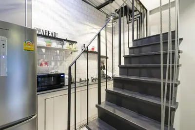 a kitchen with a staircase leading up to a microwave at Inner Old Town 196 Chic Guesthouse - self check in in Bangkok