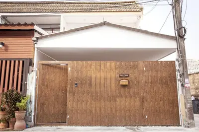 a wooden gate in front of a house at Ratchada Retreat Villa 2 in Bangkok
